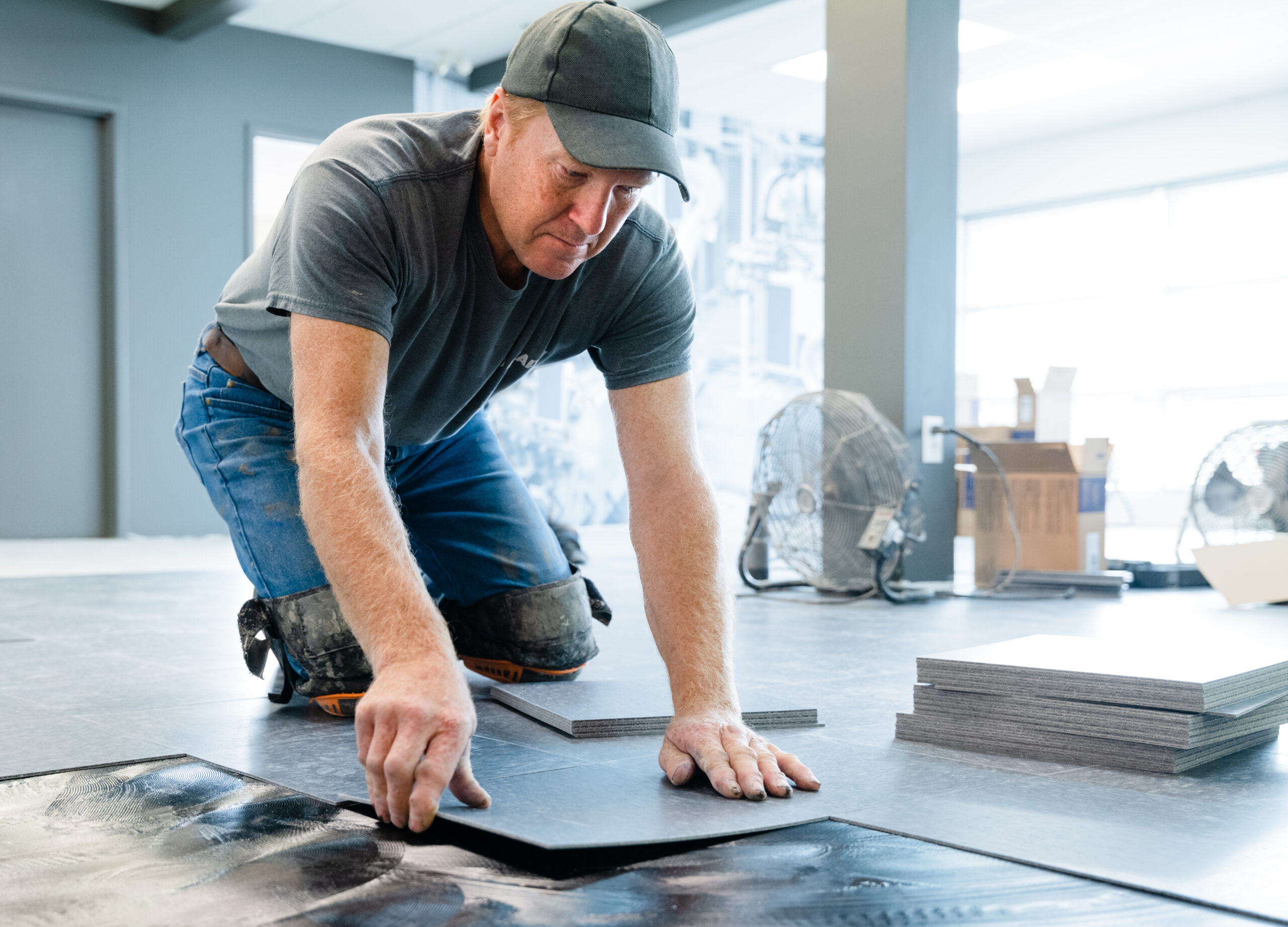 Installer laying large floor tiles
