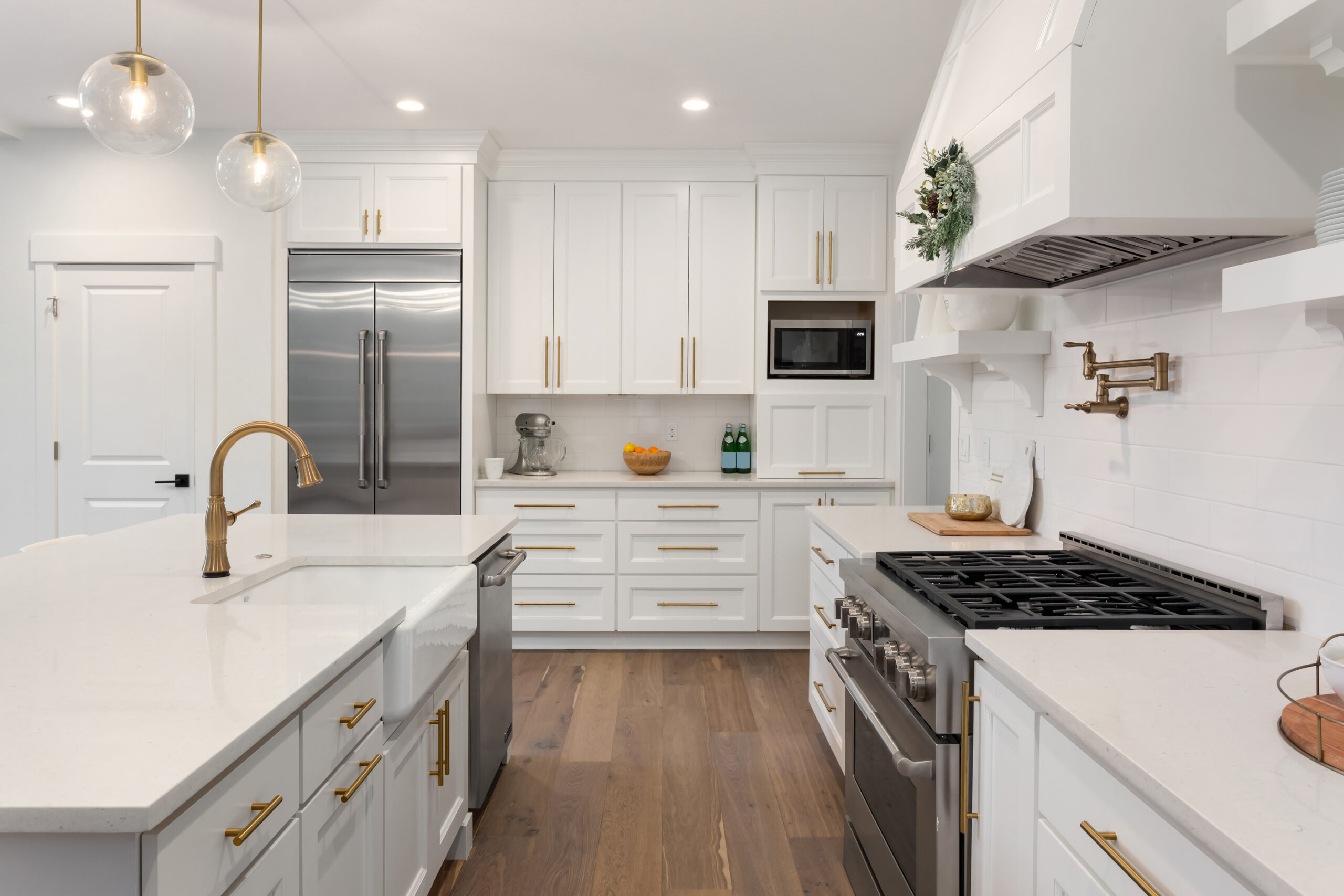 Bright white kitchen with a farmhouse sink and a wood-look floor.