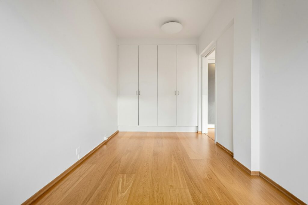 Empty room with a light wood-look floor and white walls