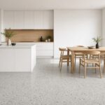 Cuisine ouverte avec un plancher de tuiles de porcelaine grises effet terrazzo en grands carrés.