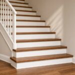 Escalier de bois teint pour s'agencer à un plancher de bois franc brun moyen, avec nez de marche et moulures assortis.