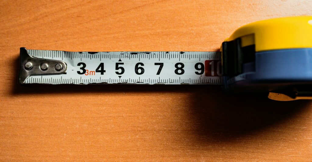 A tape measure pulled out on a wood surface